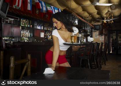 Sexy young waitress serving beer in bar