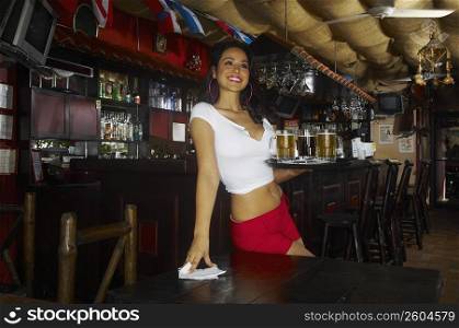 Sexy young waitress serving beer in bar