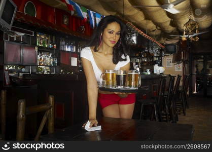 Sexy young waitress serving beer in bar