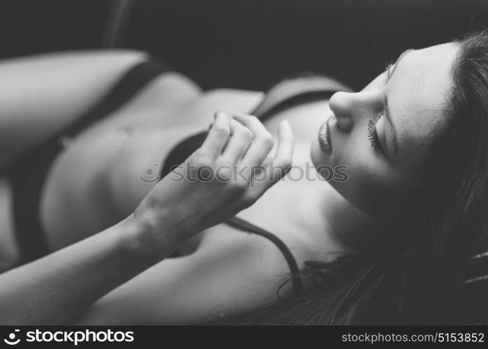 Sexy young woman in lingerie posing near wall. Soft light and colours