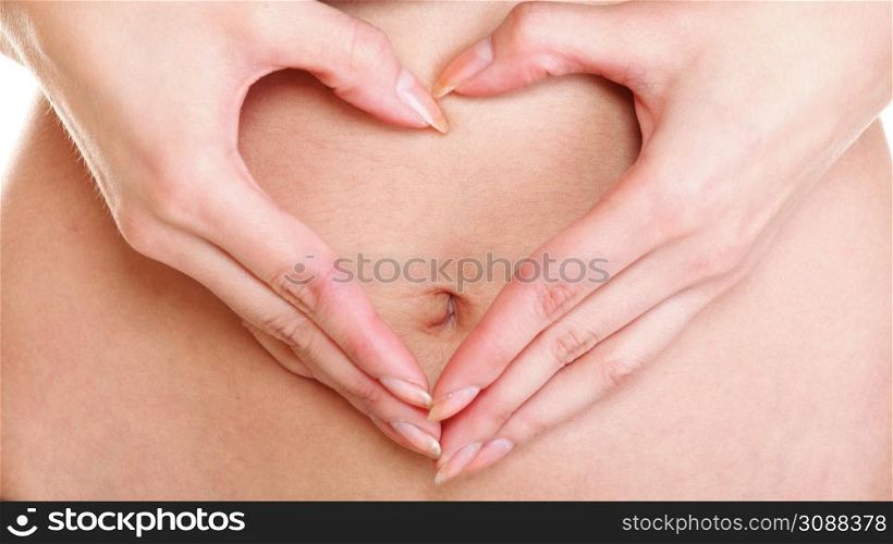 Sexy young woman making heart shape with her hands on her belly
