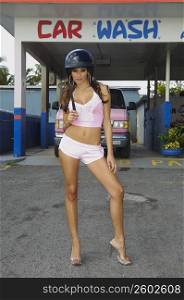 Sexy young woman posing in front of Car Wash