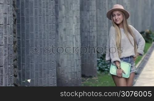 Sexy young woman posing on the city street for outdoor fashion photo on the loft brick wall background