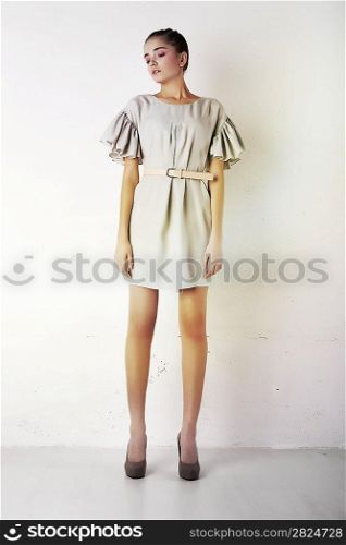 Sexy young woman wearing white short dress. Studio shot. Series of photos