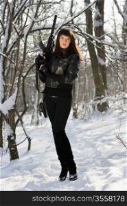 Sexy young woman with a rifle in winter forest