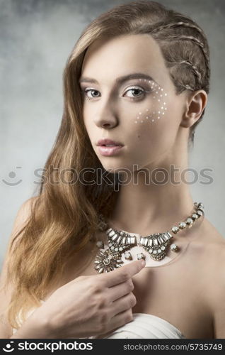 sexy young woman with creative braid hair-style, brilliant make-up, stylish necklace and white bra. artistic beauty portrait