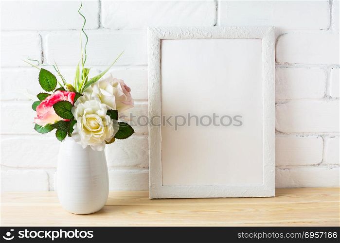 Shabby chic style white frame mockup with pink roses. Shabby chic style white frame mockup with pink roses. Empty white frame mockup for design presentation. Portrait or poster white frame mockup.