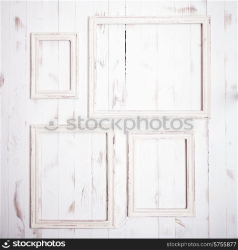 Shabby chic white frames on wooden wall. Shabby chic frames
