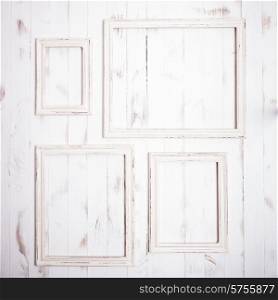 Shabby chic white frames on wooden wall. Shabby chic frames