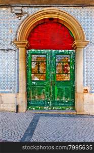 Shabby Wooden Door in the Wall Decorated with Portuguese Ceramic Tiles