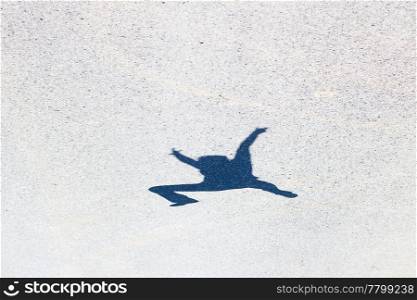 shadow of a man jumping on the asphalt
