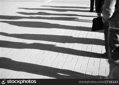 Shadow of a people standing in a queue