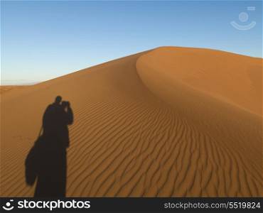 Shadow of a person on Erg Chegaga Dunes in Sahara Desert, Souss-Massa-Draa, Morocco