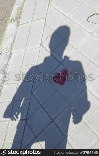 Shadow of a person with a heart painted on the floor