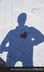Shadow of a person with a heart painted on the floor