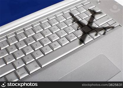 Shadow of jumbo jet over apple macintosh keyboard
