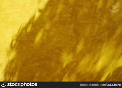 Shadow of leaves on retro style yellow wall