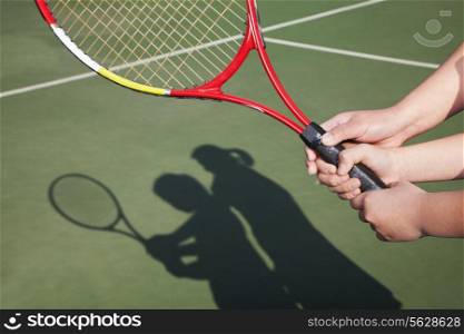 Shadow of mother and daughter playing tennis