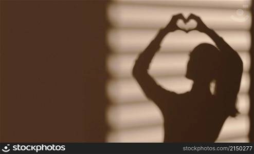 shadow woman making heart