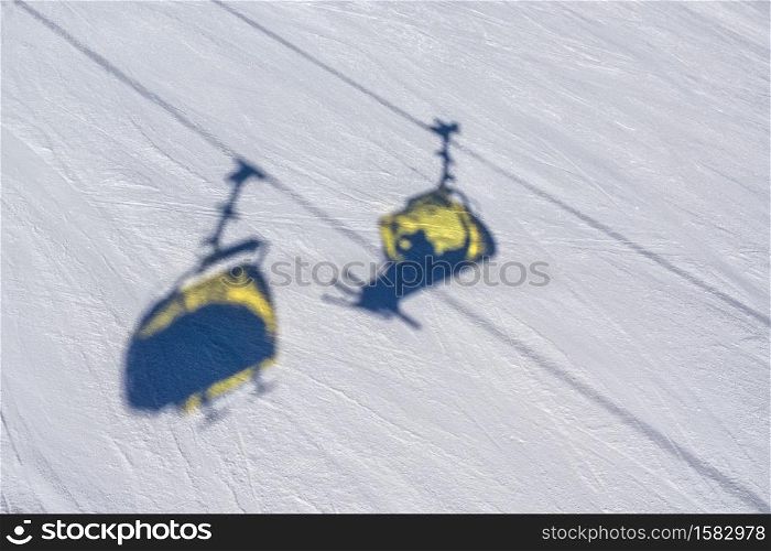 Shadows of chair lifts on the snow in the ski resort