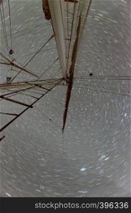 Shaft of a moving sail boat against starry sky.