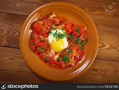 Shakshuka -dish of eggs poached in a sauce of tomatoes, chili peppers, and onions, often spiced with cumin.Moroccan, Tunisian, Libyan, Algerian, and Egyptian cuisines traditionally