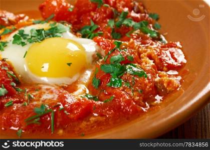 Shakshuka -dish of eggs poached in a sauce of tomatoes, chili peppers, and onions, often spiced with cumin.Moroccan, Tunisian, Libyan, Algerian, and Egyptian cuisines traditionally