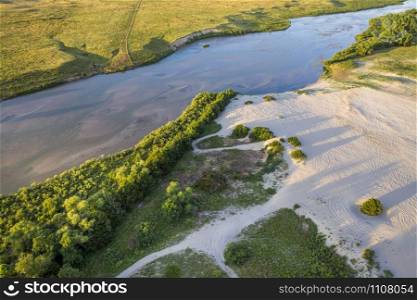 shallow and wide Dismal River flowing through Nebraska Sandhills at Nebraska National Forest, aerial view of summer scenery with sandy off road play area