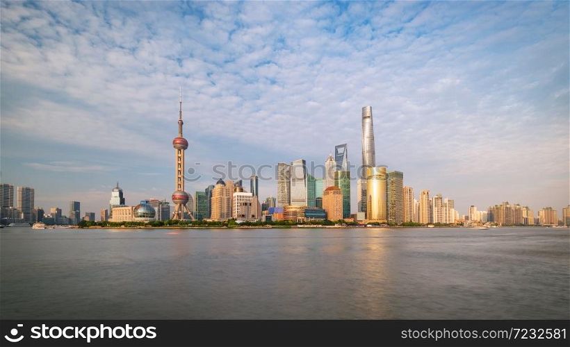 Shanghai city skyline Pudong side looking through Huangpu river on a sunny day. Shanghai, Chima. Beutiful vibrant panoramic image.. Shanghai city skyline Pudong side looking through Huangpu river on a sunny day.