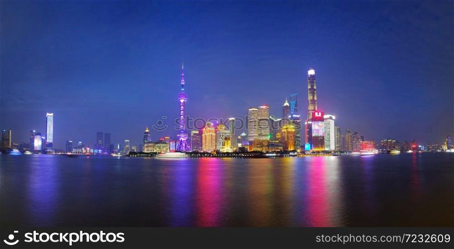 Shanghai city skyline Pudong side looking through Huangpu river on twilight time. Shanghai, China. Beutiful vibrant panoramic image.. Shanghai city skyline
