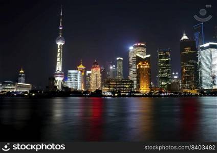 Shanghai landmark skyline at night in China with Huangpu river in forefront 
