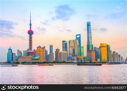 Shanghai metropolis skyline with modern architecture on river bank with scenic sunset sky on background, China