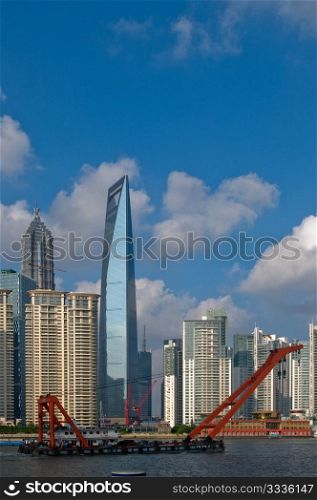 shanghai pudong view from puxi ,with big red crane boat crossing huangpu river