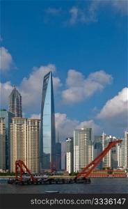 shanghai pudong view from puxi ,with big red crane boat crossing huangpu river