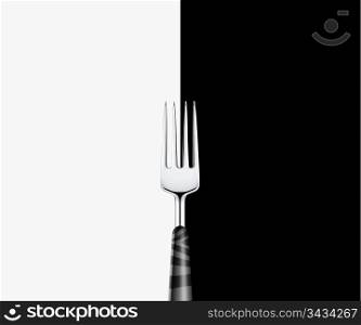 Sharp metal fork on white and black background