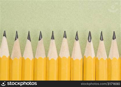 Sharp pencils arranged in an even row.