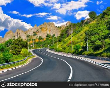 Sharp turn on the Mountain Highway against the blue sky in summer day