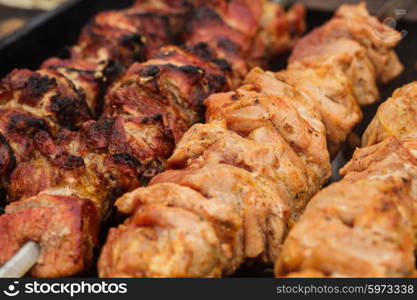 Shashlik on skewers closeup, raw and cooked