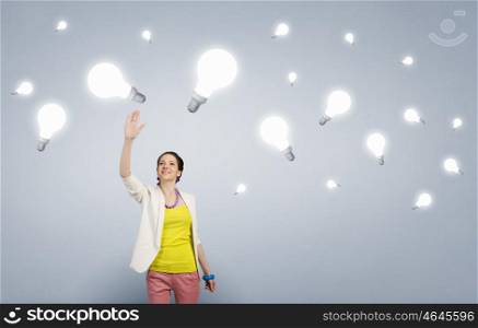 She has bright idea. Businesswoman reaching hand to touch glass glowing light bulb
