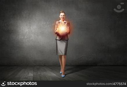 She is carrying her idea. Young businesswoman carrying big light bulb in hands