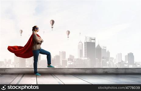 She is city guard. Young confident woman in red cape and mask
