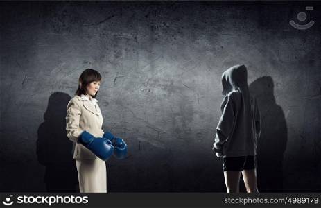 She is fighter by nature. Young businesswoman in blue boxing gloves competition ready