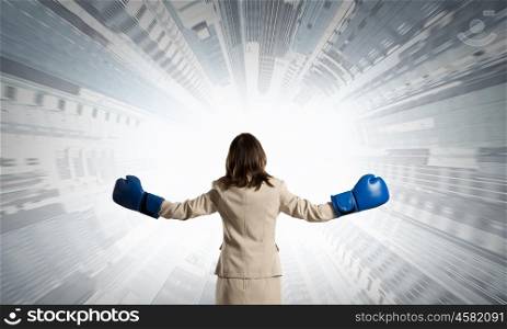 She is fighter. Young businesswoman in blue boxing gloves competition ready
