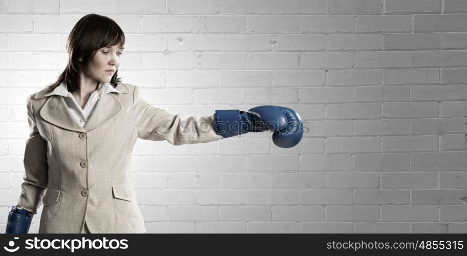 She is fighter. Young businesswoman in blue boxing gloves competition ready