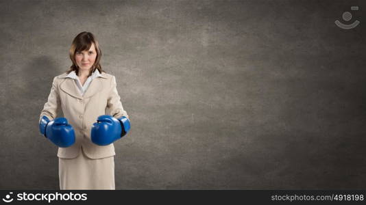 She is fighter. Young businesswoman in blue boxing gloves competition ready