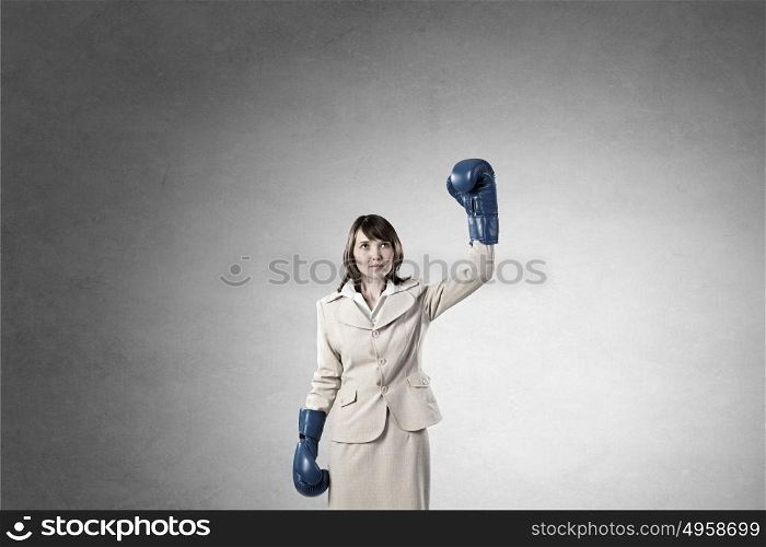She is fighter. Young businesswoman in blue boxing gloves competition ready