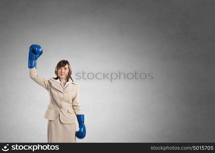 She is fighter. Young businesswoman in blue boxing gloves competition ready