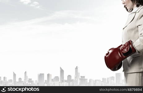She is fighter. Young businesswoman in red boxing gloves competition ready