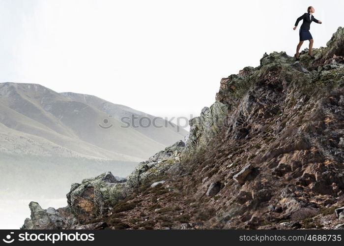 She is going to reach the top. Young determined businesswoman climbing up mountain to reach top