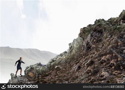She is going to reach the top. Young determined businesswoman climbing up mountain to reach top